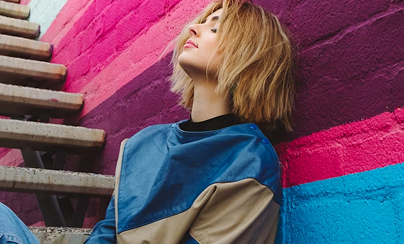 벽에 기댄 채로 앉아 있는 여성